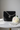 Luxury black tweed mini handbag with white sapphire chain on marble surface with white peony